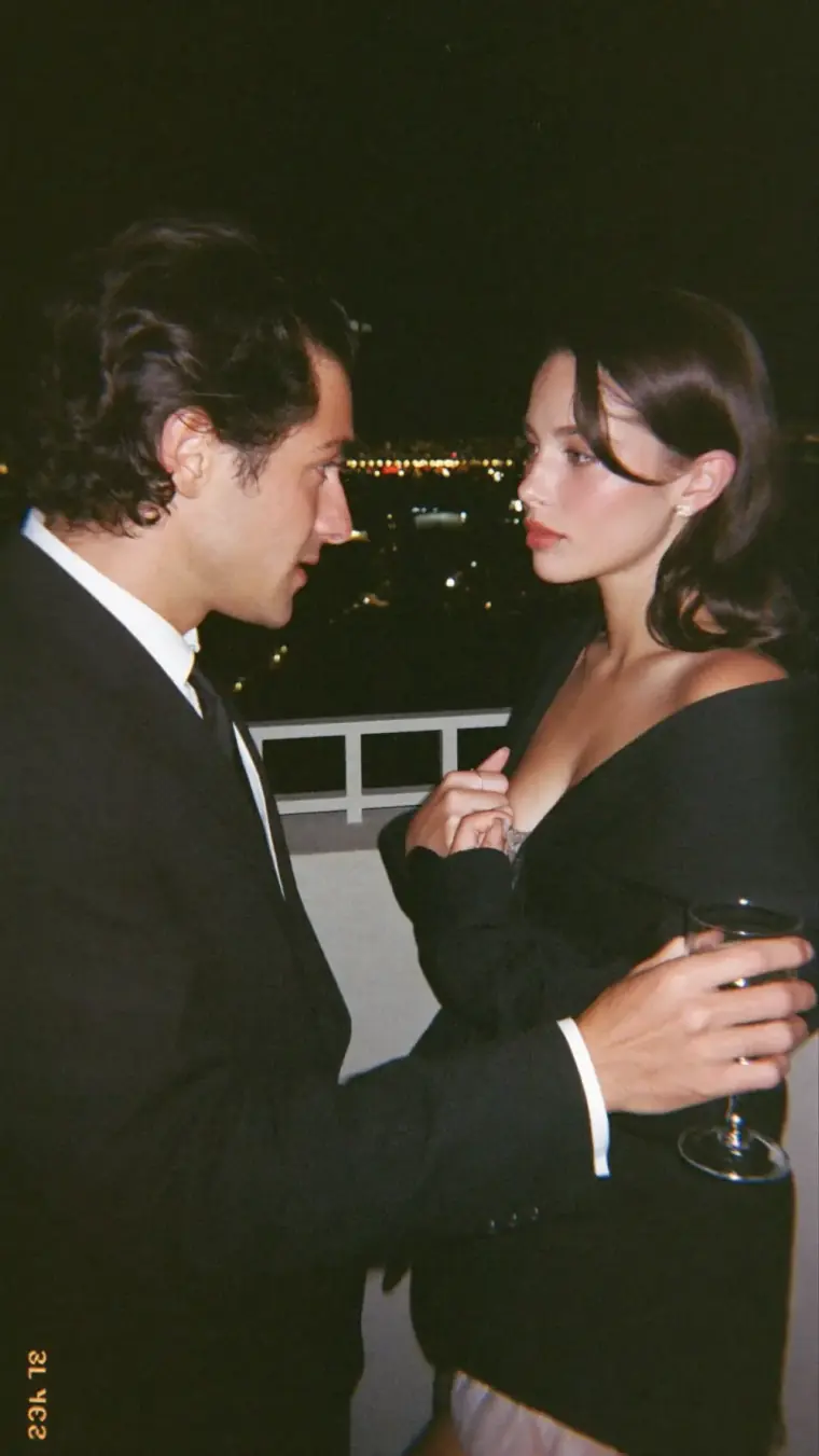 Um homem e uma mulher trocando olhares em um ambiente noturno.